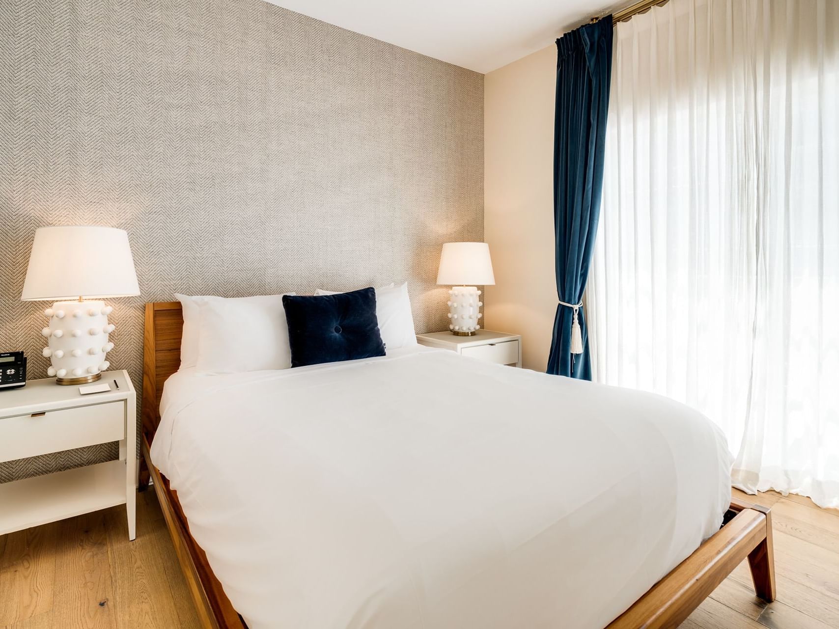 One Bedroom Queen Suite with cozy bed and wooden floors at The Savoy Hotel & Beach Club
