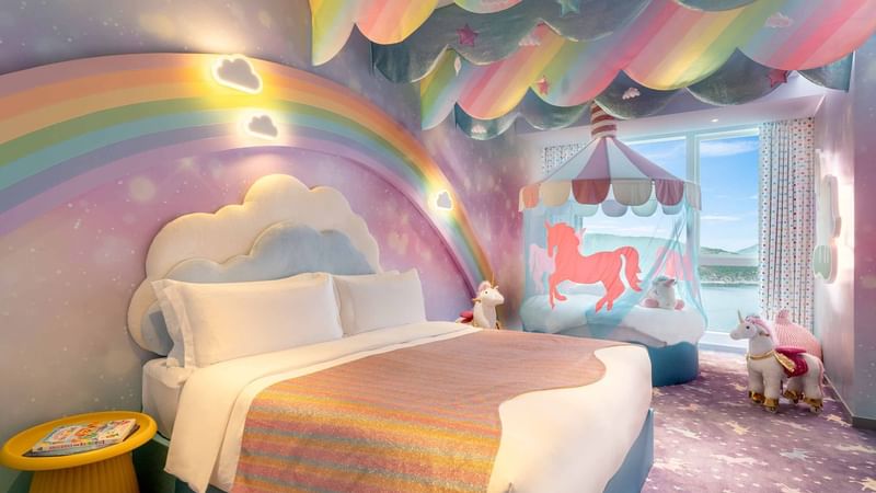 Comfy bed and sitting area in Rainbow Unicorn Room at Fullerton Ocean Park Hotel Hong Kong