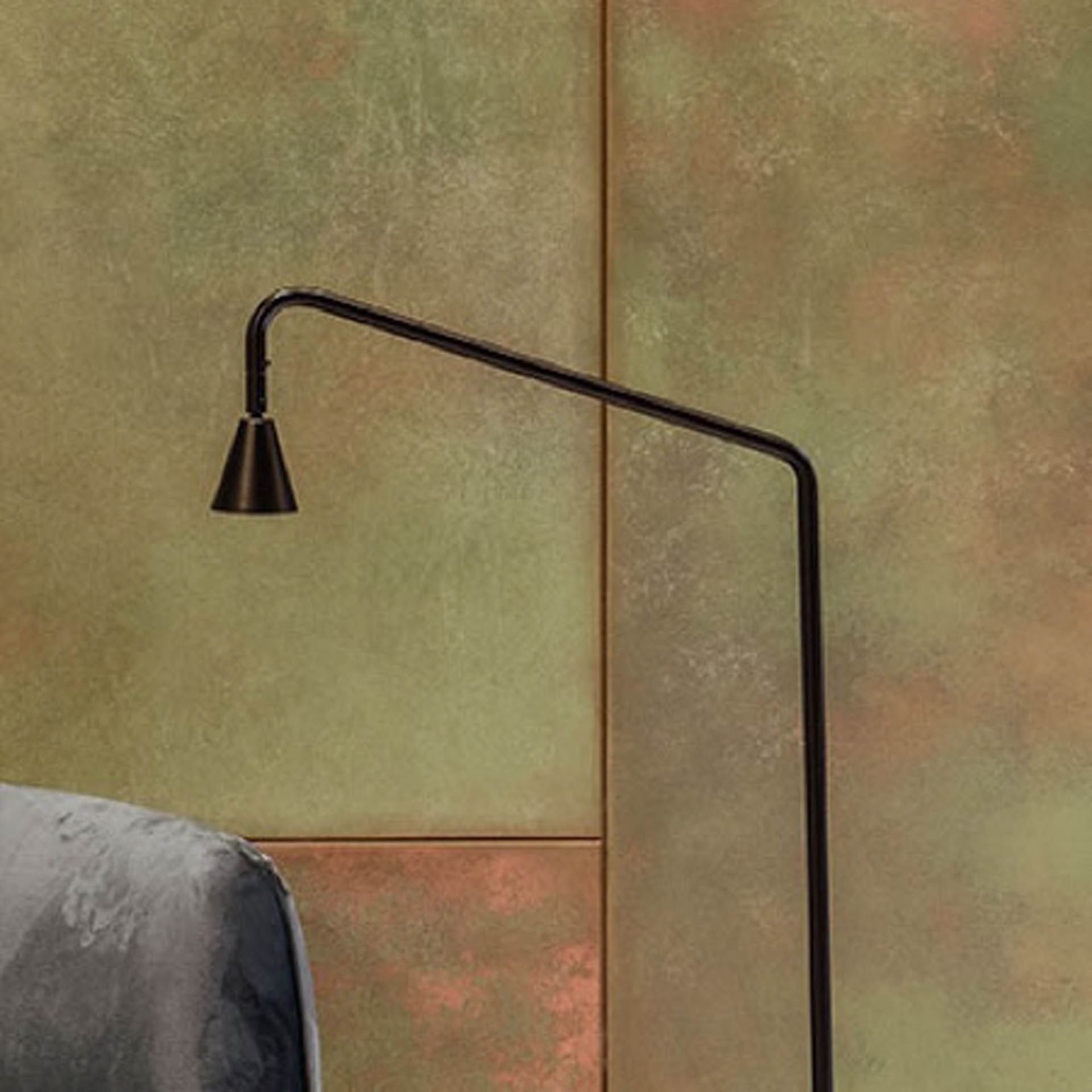 Close view of a floor lamp standing against a textured green and rust-colored wall at Almanac Barcelona