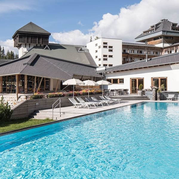 Exterior view of Falkensteiner Hotel Sonnenalpe with outdoor pool and sun loungers