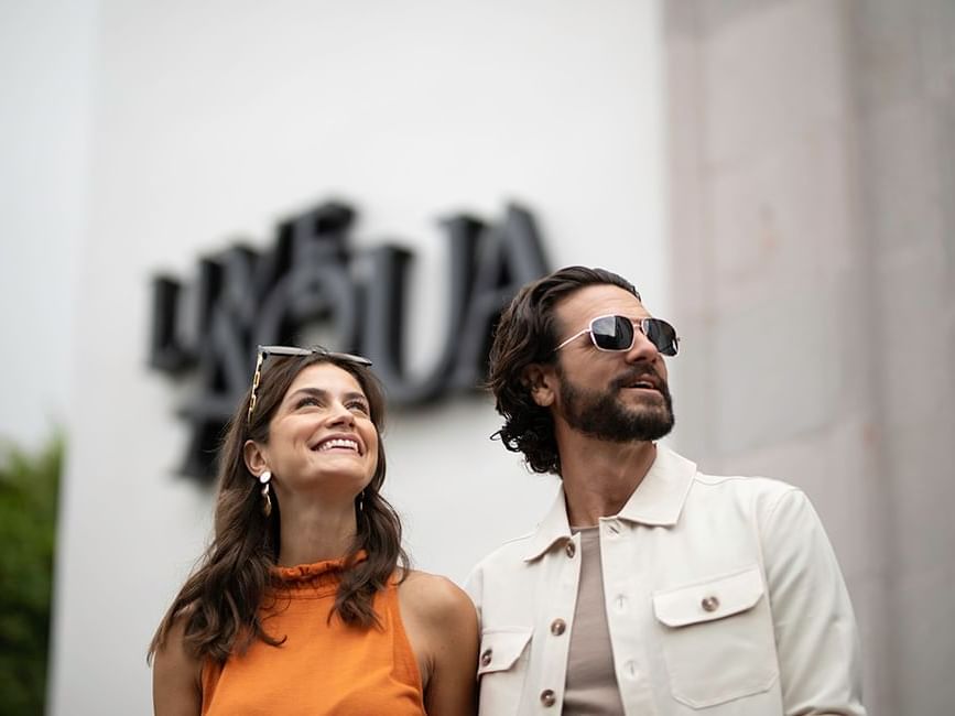 Two people standing in front of a sign with obscured faces at Live Aqua San Miguel de Allende