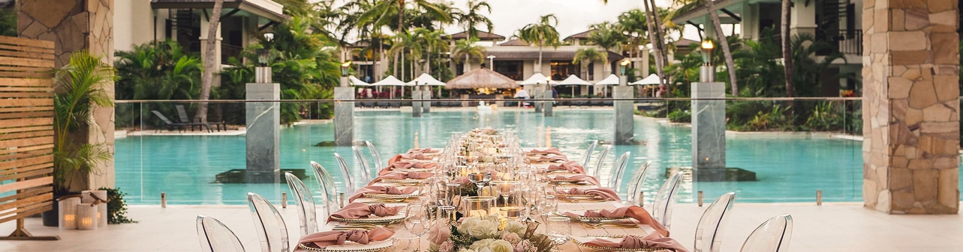 Outdoor wedding set up with long dining table by the pool in Lagoon View Terrace at Pullman Port Douglas
