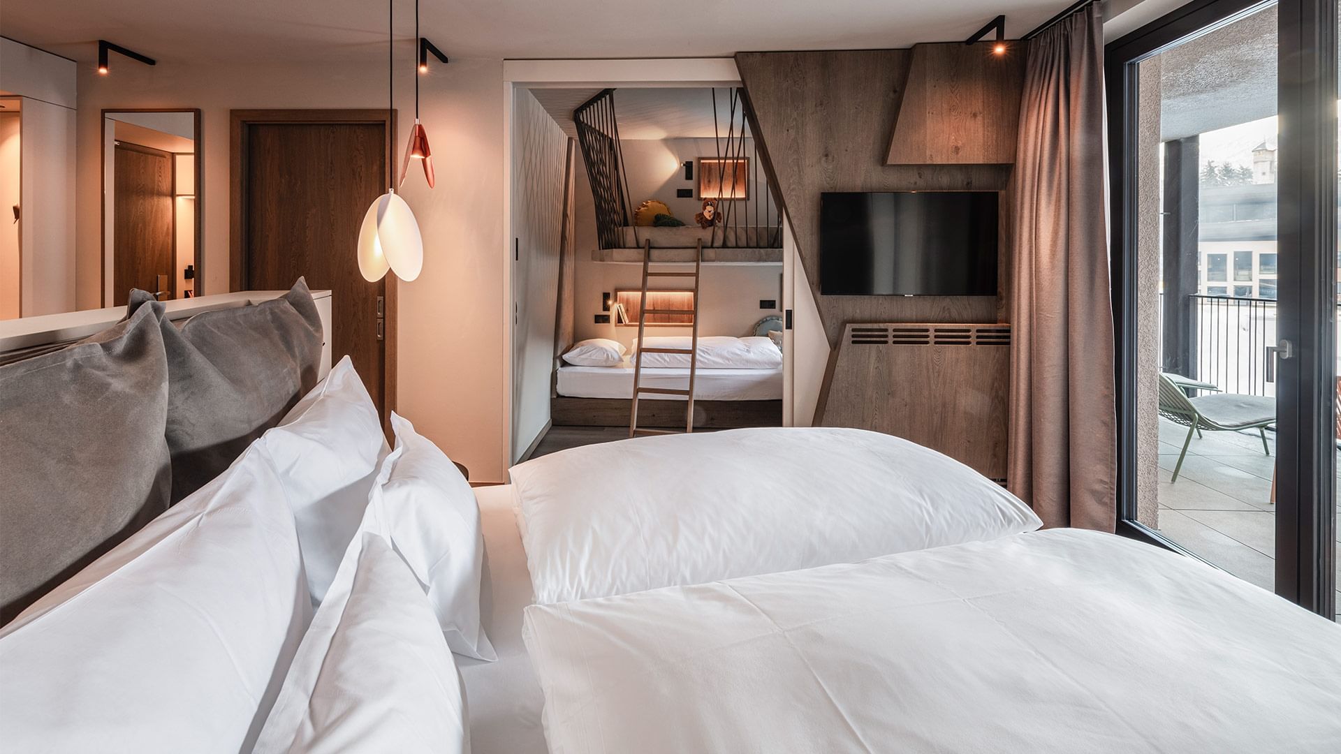 Premium Suite Falkynest with white bedding and a mezzanine loft bed at Falkensteiner Family Resort Lido