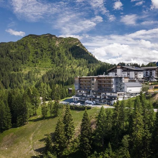 Distant view of Falkensteiner Hotel Sonnenalpe surrounded by greenery