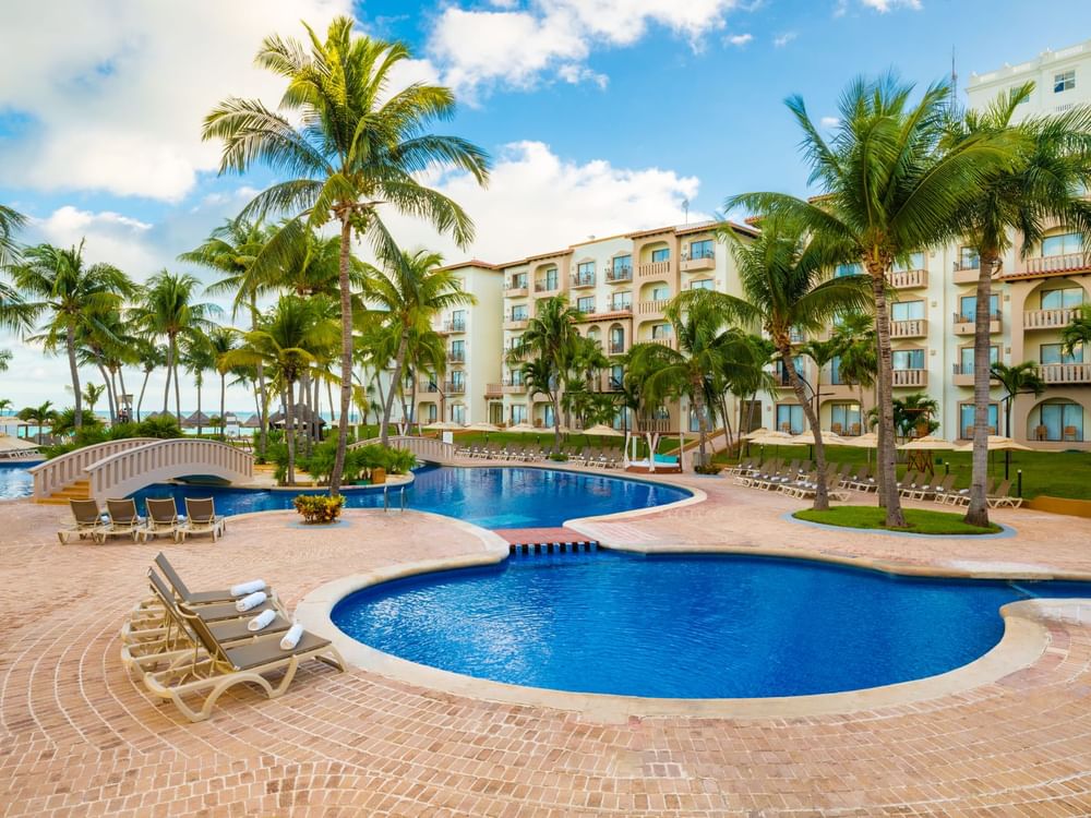 Sunbeds by the outdoor pool area at Fiesta Americana Travelty