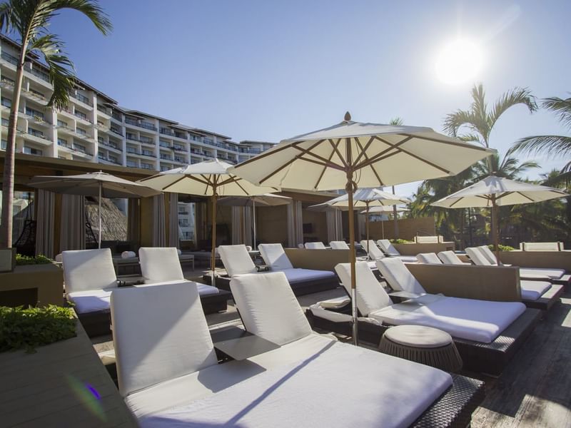 Sunbeds and patio umbrellas arranged outdoors at Fiesta Americana