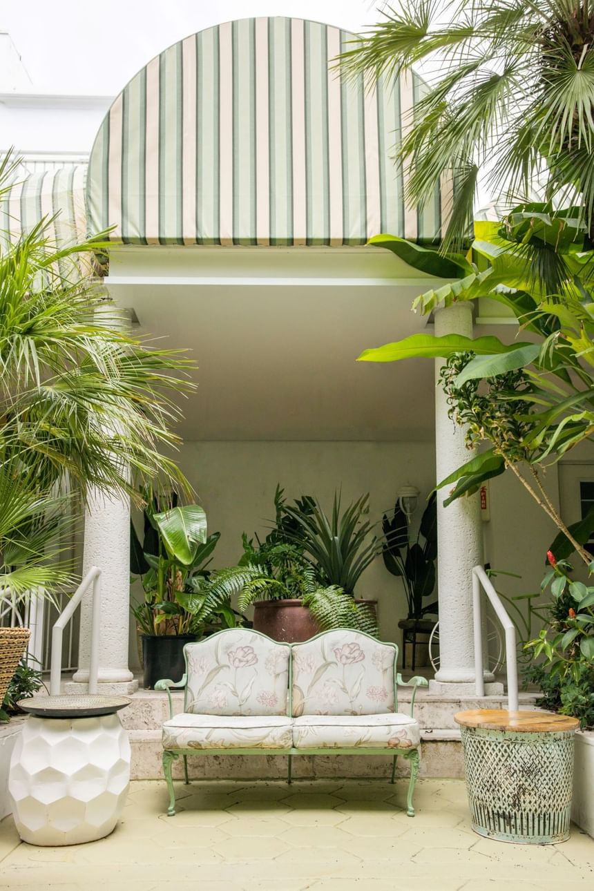 A white couch on the porch in Garden at The Savoy Hotel & Beach Club