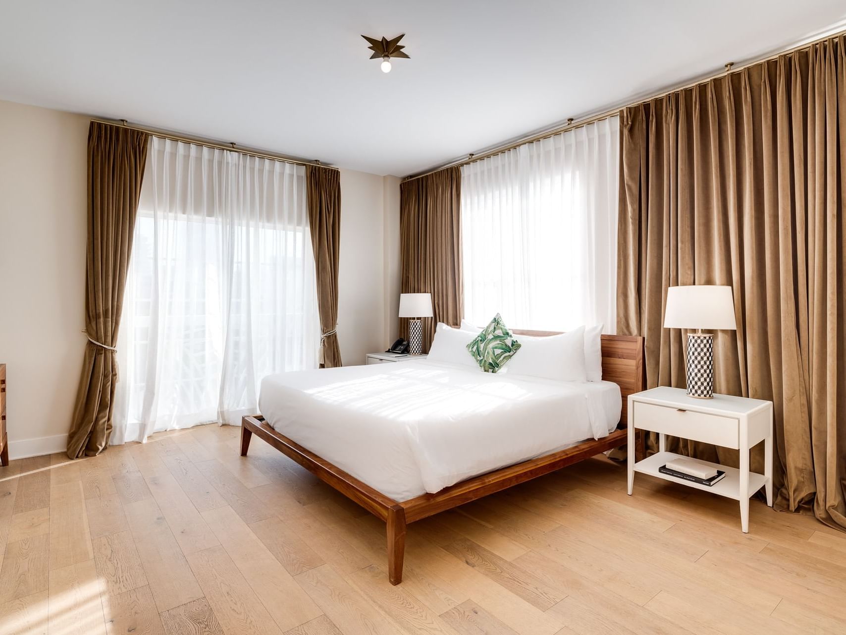 Nightstands by the bed in Grand One Bedroom King Suite with Balcony at The Savoy Hotel & Beach Club