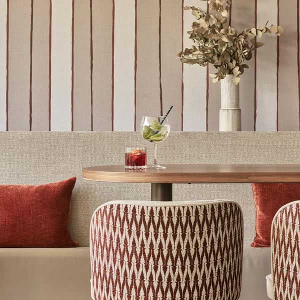 Close-up of sitting area with two drinks served on a table at Falkensteiner Hotel & Spa Carinzia